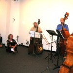 Cheri, quartet2 audience members are sitting on the floor near the musicians